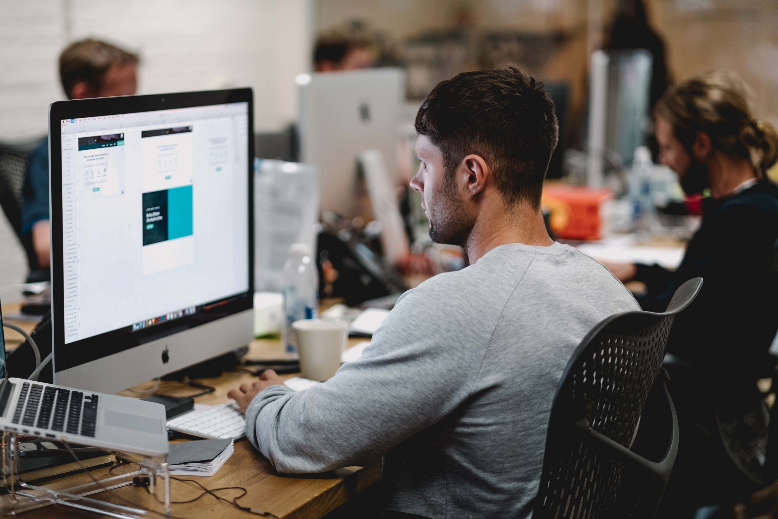 Employee working at his desk in a busy office environment